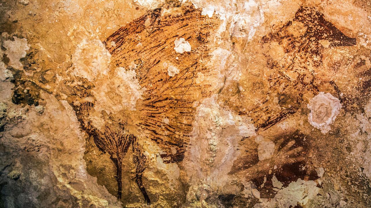 A cave painting in Sulawesi,Indonesia is the oldest known artwork made by humans. Image via Kinez Riza.